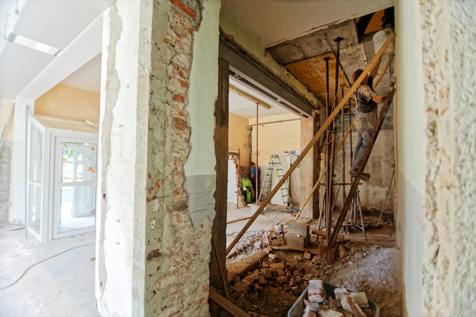 Gutted interior mid-renovation with exposed brick and temporary props