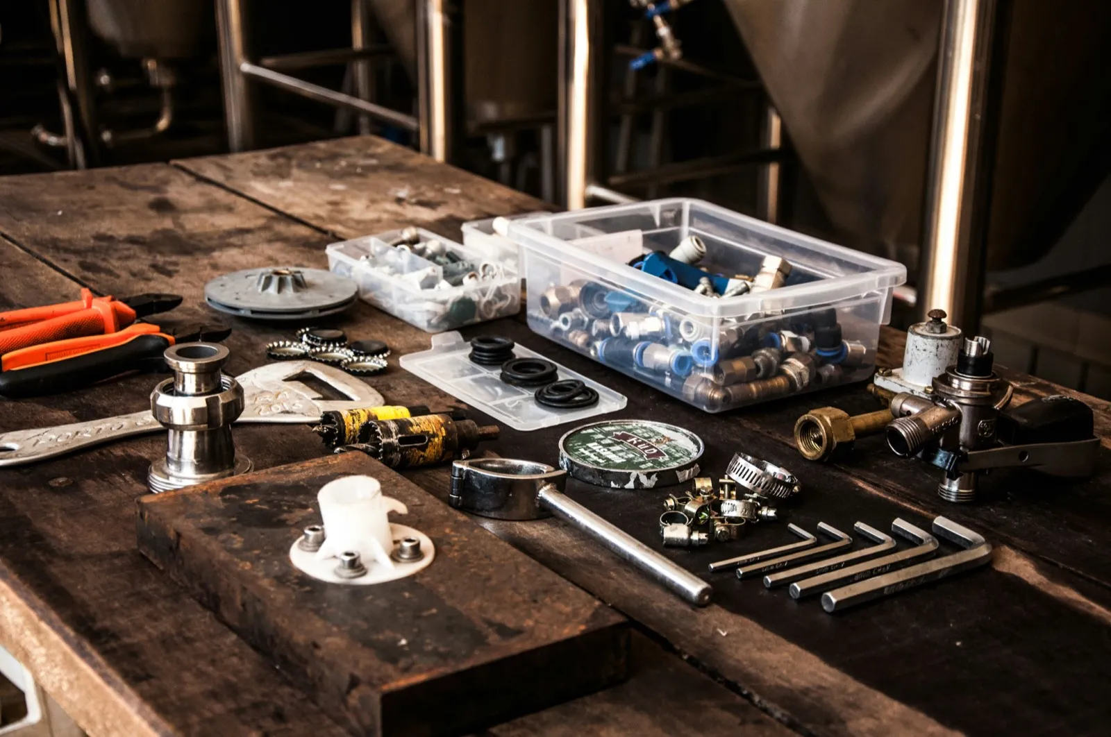Fittings, fasteners, and hand tools laid out on a workbench