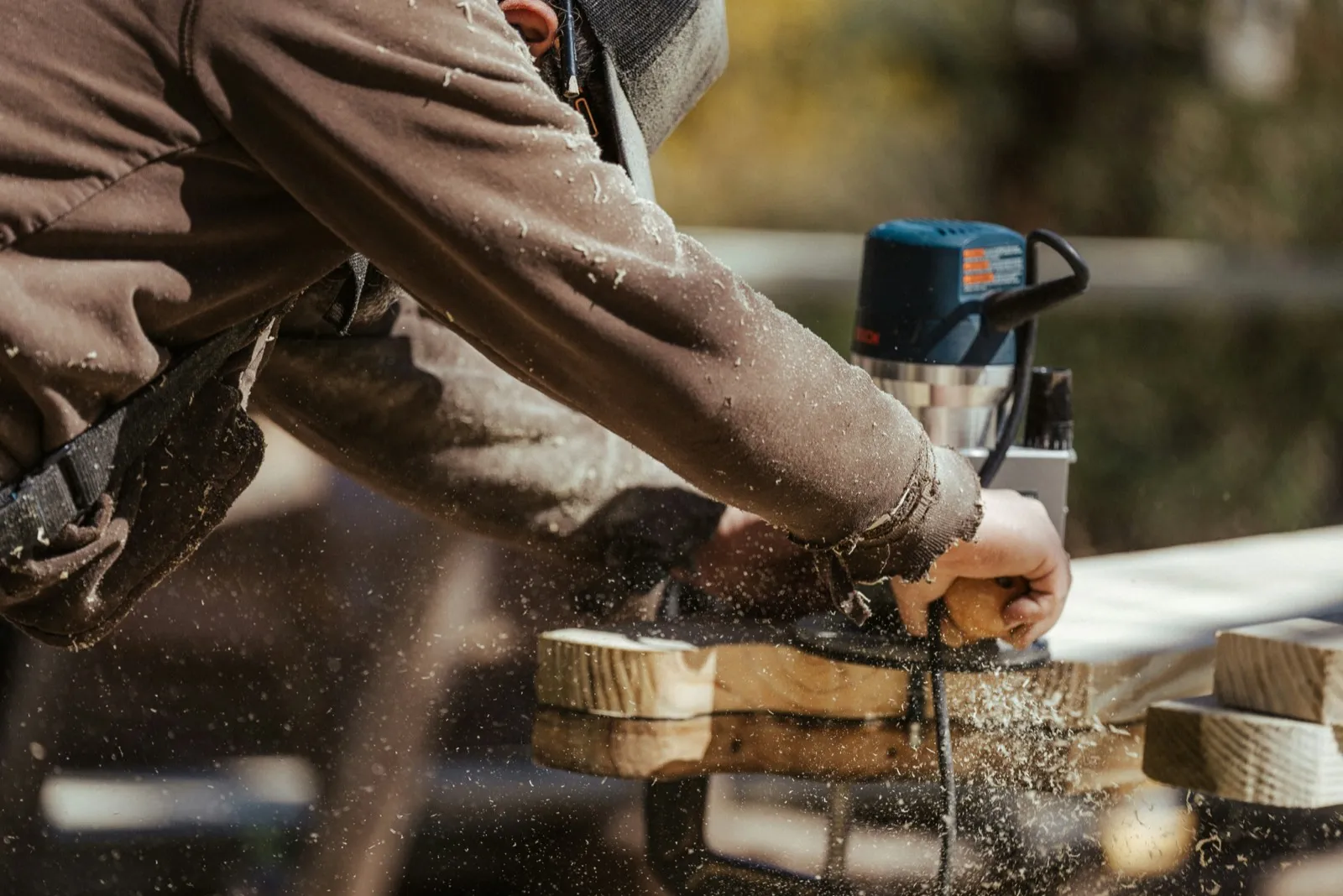 Remodeler running a power planer, sawdust flying